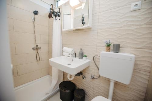 a bathroom with a sink and a toilet and a tub at Studio apartmant Tonka in Šibenik