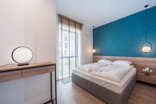 una camera con un grande letto con una parete blu di Yacht Park Marina View - BillBerry Apartments a Gdynia