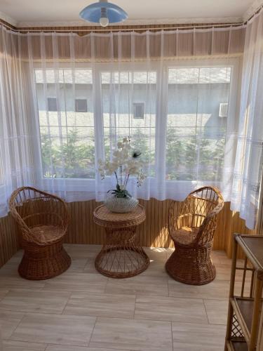 a room with three chairs and a table in front of a window at Törpi Apartman in Halmaj