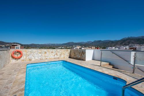 a swimming pool on the roof of a house at Hotel Toboso Chaparil in Nerja