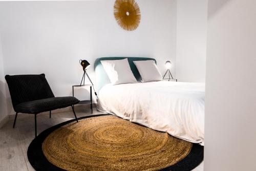 a bedroom with a bed with a chair and a mirror at Le Rinaldi LOFT in Albi