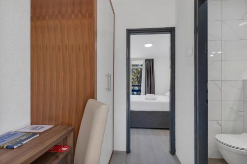 a bathroom with a sink and a toilet and a mirror at Hotel Alem in Baška Voda