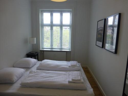 Duas camas num quarto branco com uma janela em Australiensvej em Copenhague