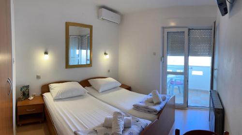 een slaapkamer met 2 bedden en een spiegel bij Sunrise Apartments and Studio Apartments 1 in Lokva Rogoznica