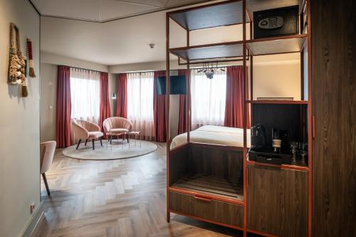 Hotel Greenside Texel في دي كوخ: غرفة نوم مع سرير بطابقين وغرفة معيشة