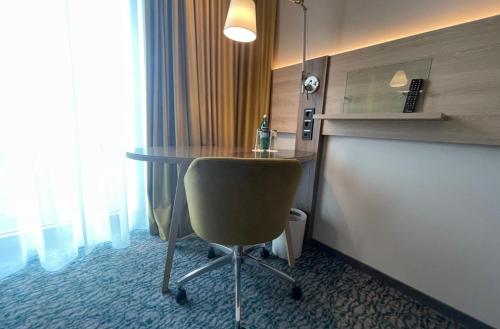 a room with a table and a chair in a room at Holiday Inn Düsseldorf City – Toulouser Allee by IHG in Düsseldorf