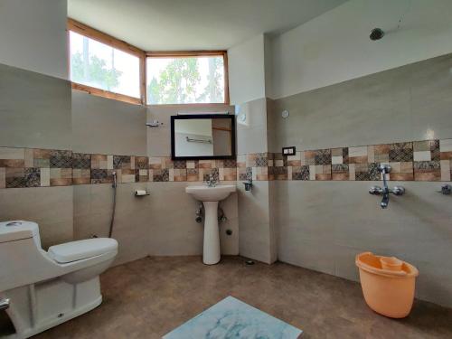 un bagno con un water, un lavandino e una finestra di Glacier View Guest House a Leh