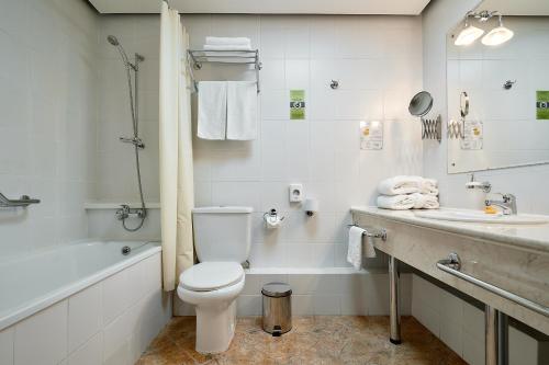 a bathroom with a toilet and a tub and a sink at Voznesensky Hotel in Yekaterinburg