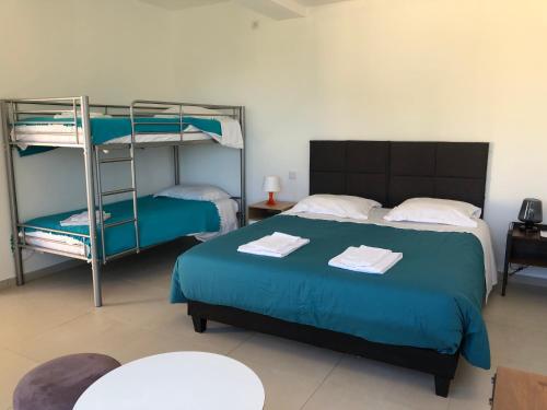 1 Schlafzimmer mit 2 Etagenbetten und einem Tisch in der Unterkunft Hotel La Cigale in La Croix-Valmer