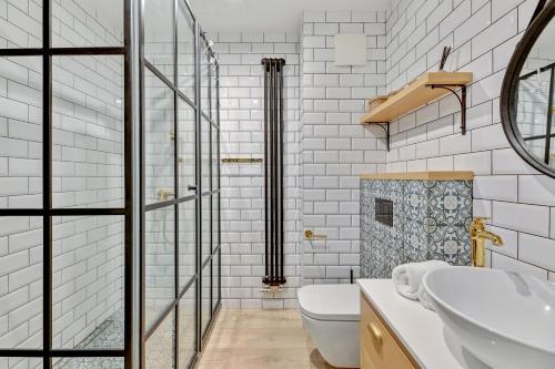 a white bathroom with a sink and a toilet at Winter Residence Apartinfo Apartments in Gdańsk