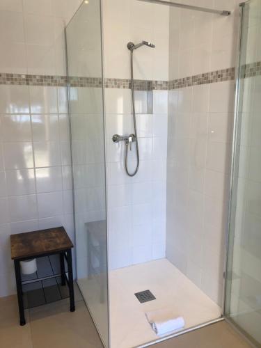 a shower with a glass door next to a table at Hotel La Cigale in La Croix-Valmer