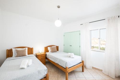 1 Schlafzimmer mit 2 Betten und einem Fenster in der Unterkunft Albufeira - 3 bedrooms - free wifi in Albufeira