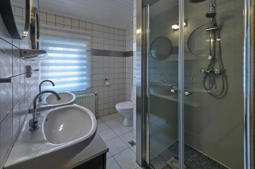 La salle de bains est pourvue d'un lavabo, d'une douche et de toilettes. dans l'établissement Meschermolen 4, à Mesch