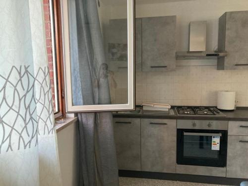 een keuken met een persoon die een foto neemt in een spiegel bij Appartamento sulla piazza 90 m dal mare in Anzio