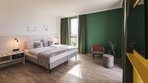 een slaapkamer met een bed en een groene muur bij the niu Tab in Düsseldorf