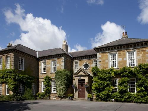 un gran edificio de ladrillo con una puerta en la parte delantera en Sutton Hall Resort, en Thirsk