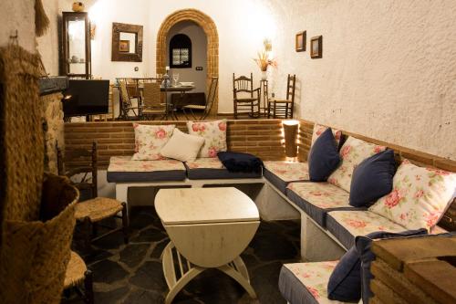 a living room filled with furniture and a couch at Hábitat Troglodita Almagruz in Purullena