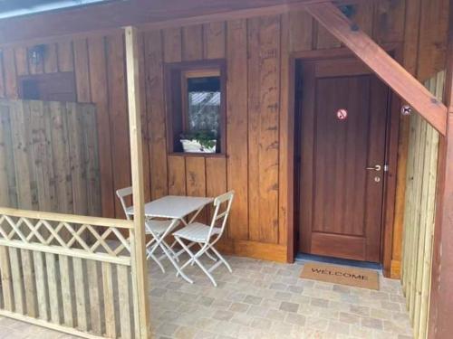a house with a table and a door and a table and chairs at Gîte Little Creek in Hamoir
