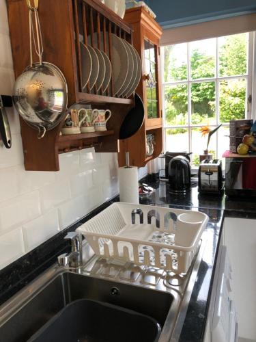 a kitchen sink with a dish drying rack above it at Little Treasure with up to 25 percent off ferry in Shanklin