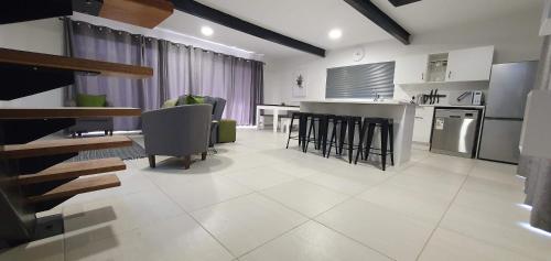 a kitchen and living room with a table and chairs at Wilgespruit Manor Flat in Roodepoort