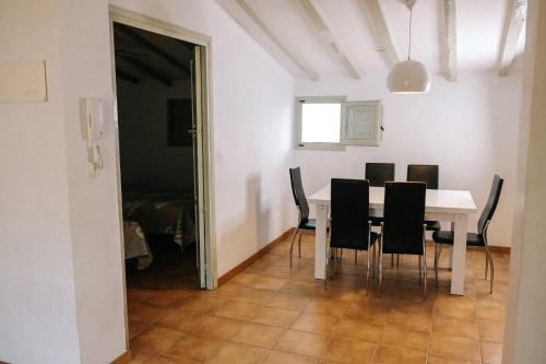 uma sala de jantar com uma mesa branca e cadeiras pretas em Apartamentos Villaaltea - Luna em Altea