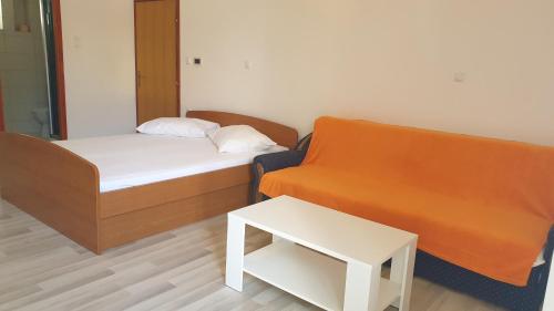 Zimmer mit einem Bett, einem Sofa und einem Tisch in der Unterkunft Apartments Milka Pag in Pag