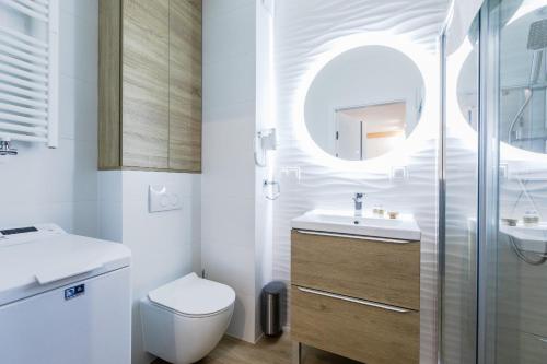 a bathroom with a toilet and a sink and a mirror at Resort Apartamenty Klifowa Rewal 54 in Rewal