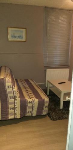 1 dormitorio con 1 cama y 1 mesa en LE CREUSOT, en Le Creusot