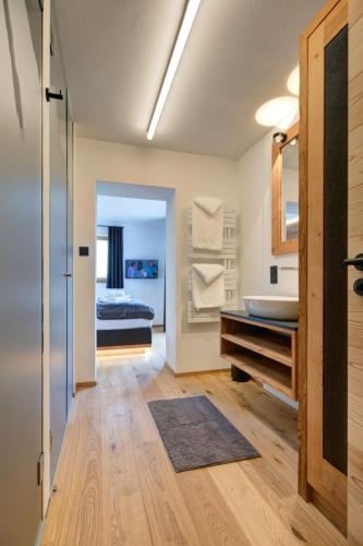 a bathroom with a sink and a bed in a room at designchalets auf 685 in Reit im Winkl