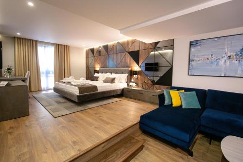 une chambre d'hôtel avec un lit et un canapé dans l'établissement Hotel Sokrati, à Tirana