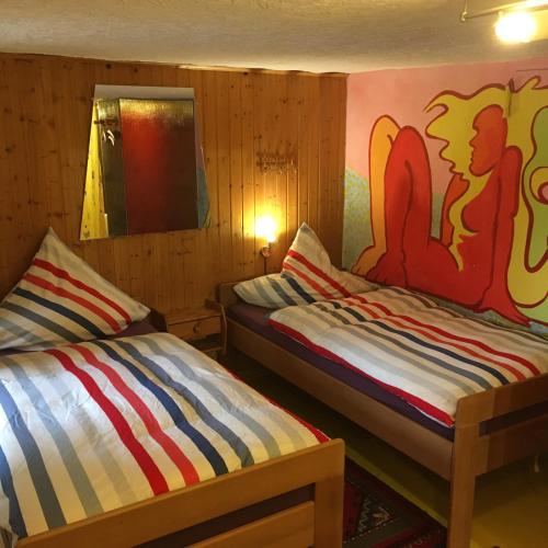 a bedroom with two beds and a painting on the wall at Pension Weinsberg in Weinsberg