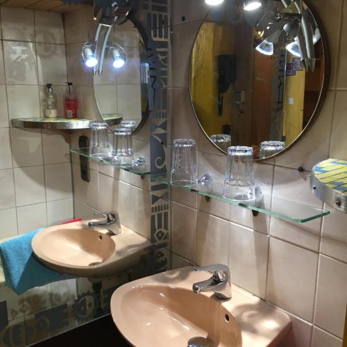 a bathroom with two sinks and two mirrors at Pension Weinsberg in Weinsberg