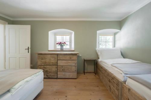 ein Schlafzimmer mit 2 Betten und eine Kommode mit einem Fenster in der Unterkunft Braumeisterhaus Schloss Eggenberg in Eggenberg