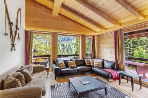 a living room with a couch and a table at Chalet Nirvana by Mrs Miggins in Champéry