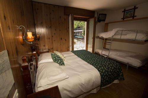 a bedroom with a bed and bunk beds with a window at Hotel Edelweiss in Limone Piemonte