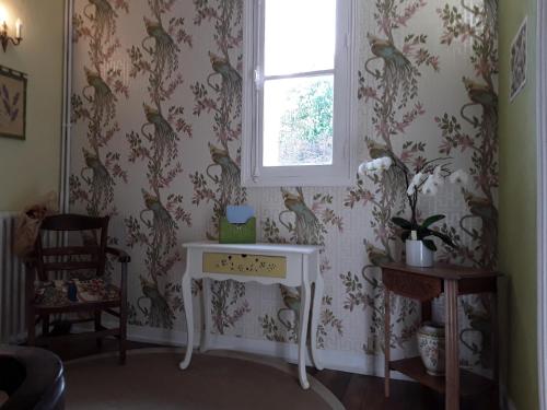 a room with a table with a bird wallpaper at CHANTOISEAU in Ligueil