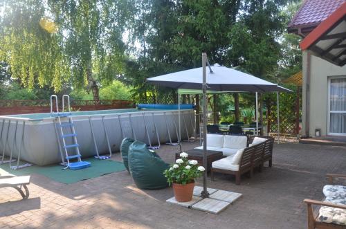 a pool with an umbrella and some chairs and a table at Marta in Okuninka