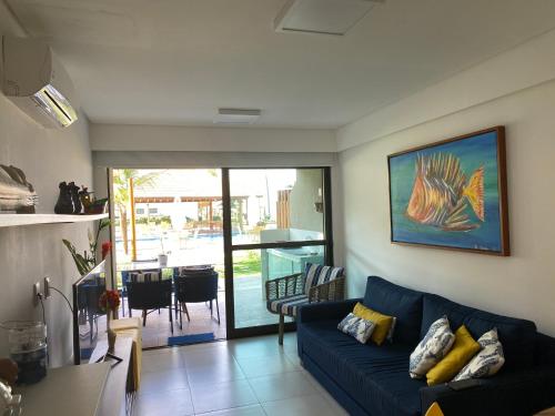 un soggiorno con divano blu e tavolo di Flat Polinésia Térreo Piscina Privativa a Porto De Galinhas