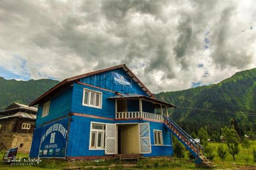 une maison bleue assise au-dessus d'un champ dans l'établissement State Continental Hotel, à Arangkēl