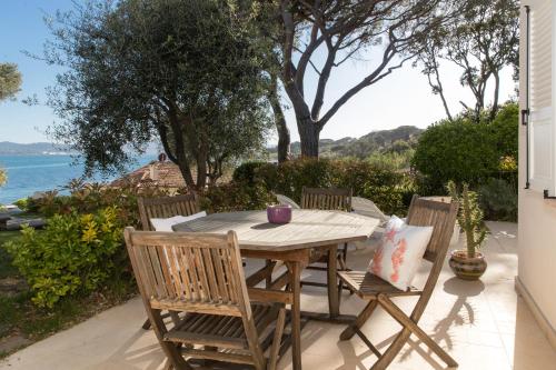 einen Tisch und Stühle auf einer Terrasse mit Meerblick in der Unterkunft Villa Pointe Alègre in Grimaud