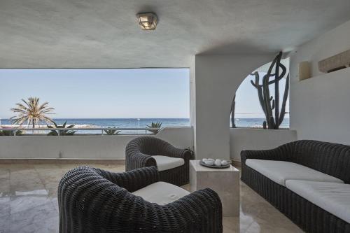 una sala de estar con sillas y vistas al océano. en Seafront Apartment with 2 bedrooms in Puerto Banús, en Marbella