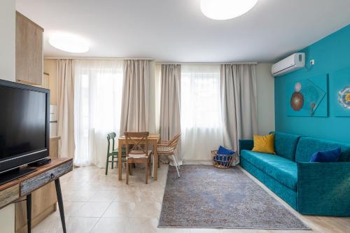 a living room with a blue couch and a table at Turquoise in Pomorie