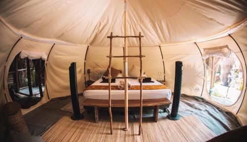 Uman Glamping & Cenote Tulum في تولوم: غرفة نوم في خيمة فيها سرير