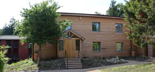 une maison en bois avec une porte en bois devant elle dans l'établissement South Downs Eco Lodge & Camping, à East Meon