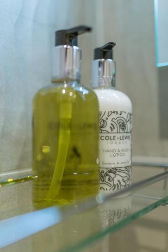 two bottles of soap sitting on a glass shelf at Best Western Sysonby Knoll Hotel in Melton Mowbray