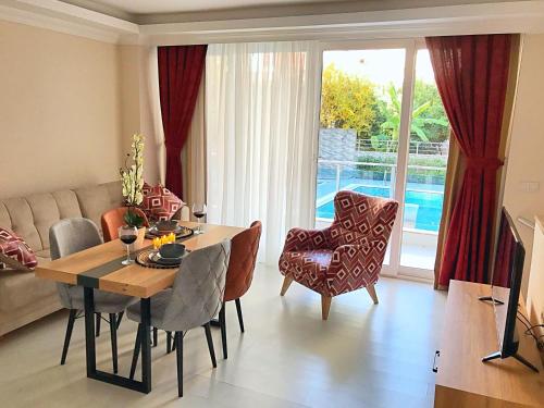 a living room with a table and chairs and a couch at Alfa Apart Hotel in Antalya