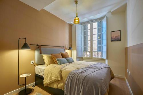 a bedroom with a bed and a large window at Attic Teatro in Málaga