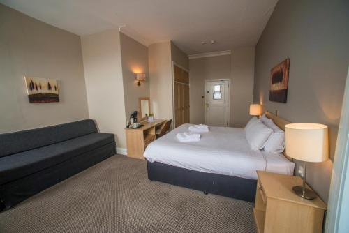a hotel room with a bed and a couch at Old Colonial, Weston-Super-Mare by Marston's Inns in Weston-super-Mare