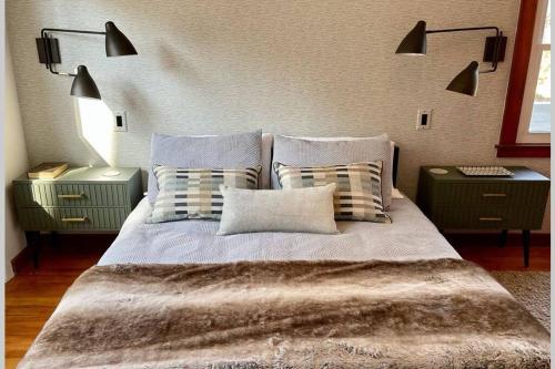 1 dormitorio con 1 cama con almohadas y 2 mesitas de noche en Peaceful Getaway Cottage on grounds of historic mid-century gem, en Northborough