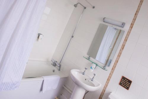a bathroom with a sink and a toilet and a mirror at Old Colonial, Weston-Super-Mare by Marston's Inns in Weston-super-Mare